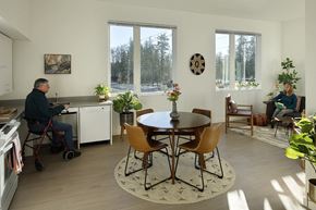St Helens townhouse for rent - A man in a wheelchair is sitting at a table in a kitchen.
