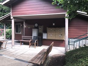 Sandy apartment for rent - a porch in front of a red house with a wooden bench