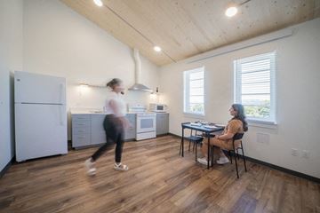 Portland apartment for rent - a living room and kitchen with a woman sitting at a table