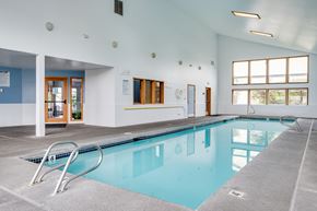 Vancouver apartment for rent - a swimming pool in a large room with a pool table and chairs