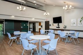 Mcminnville apartment for rent - a dining room with white tables and chairs and a television