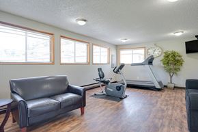 Vancouver apartment for rent - A living room with a couch, a treadmill, and a television.