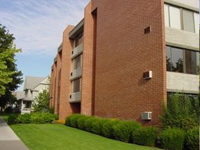 Spokane apartment for rent - A red brick building with a green lawn in front.