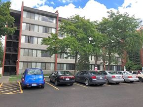 Spokane apartment for rent - A blue car is parked in a parking lot in front of a building.