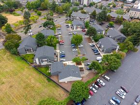 Portland apartment for rent - A parking lot with cars and a building in the background.