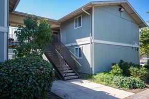 Albany apartment for rent - A grey house with a black metal staircase leading to the front door.
