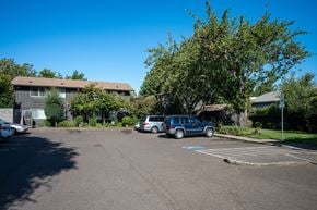 Corvallis apartment for rent - A parking lot with cars and a building in the background.