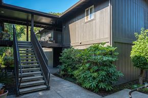Corvallis apartment for rent - A house with a wooden exterior and a staircase leading to a balcony.