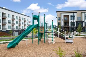 Beaverton apartment for rent - A playground with a green slide and a brown sandy area.