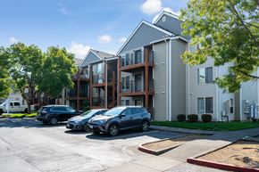 Portland apartment for rent - A parking lot with cars and apartment buildings.
