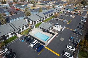 Redmond apartment for rent - A parking lot with cars and a swimming pool in front of apartment buildings.