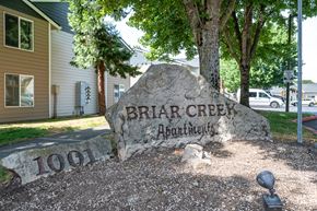 Hillsboro apartment for rent - A large rock with the words Briar Creek Apartments and the number 1001 on it.