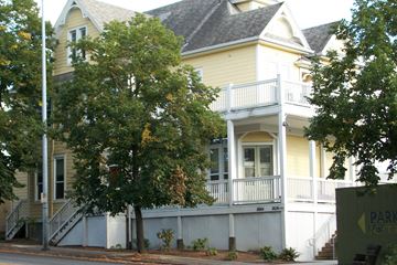 Portland apartment for rent - a white and yellow house with a porch and a tree