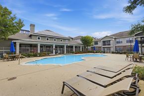 Austin apartment for rent - A pool area with sun loungers and a building in the background.