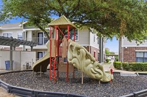 Austin apartment for rent - A playground with a slide and a tree in the background.
