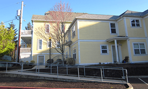 Portland apartment for rent - a yellow house with a sidewalk in front of it