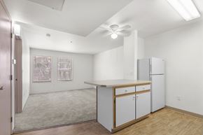 Los Ranchos De Alebuquerque apartment for rent - A kitchen with white cabinets and a ceiling fan.