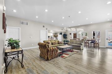 Los Ranchos De Albuquerque apartment for rent - A living room with a striped couch and a wooden floor.