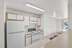 Albuquerque apartment for rent - A kitchen with white appliances and wooden accents.