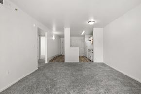 Albuquerque apartment for rent - A spacious, empty room with white walls and a grey carpet.