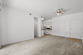 Albuquerque apartment for rent - A spacious room with a ceiling fan and a desk with a chair.