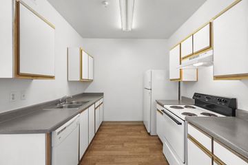 Albuquerque apartment for rent - A kitchen with white cabinets and a black stove top oven.