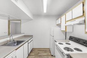 Albuquerque apartment for rent - A white kitchen with a stove top oven and a sink.