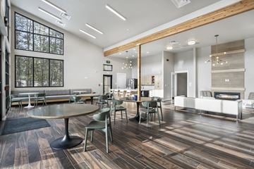 Bend apartment for rent - a communal area with tables and chairs and a living room with a fireplace