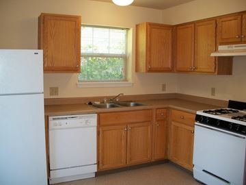 Beaverton apartment for rent - a kitchen with white appliances and wooden cabinets