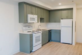 Portland apartment for rent - a kitchen with white appliances and blue and white cabinets