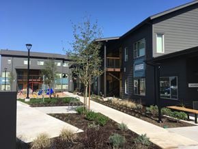 Molalla apartment for rent - a view of the exterior of a building with a sidewalk and trees