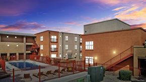 Los Ranchos De Albuquerque apartment for rent - A building with a pool in front of it.