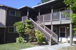 Winston apartment for rent - A brown house with a deck and stairs leading to the front door.