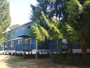 Renton apartment for rent - A blue house with a deck and trees in front.