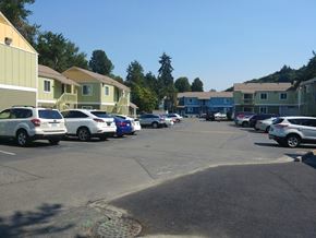 Renton apartment for rent - A parking lot with cars and apartment buildings in the background.