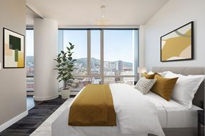 Portland apartment for rent - A bedroom with a large bed and a view of the city.