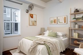 Portland apartment for rent - a bedroom with a bed and shelves and a window