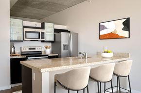 Portland apartment for rent - a kitchen with a marble counter top with three stools