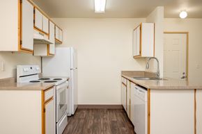 Hillsboro apartment for rent - A kitchen with white appliances and wooden cabinets.