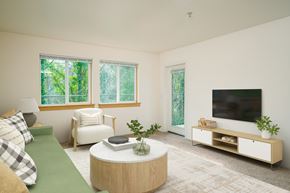 Hilsboro apartment for rent - A living room with a green couch, a white chair, a round table, and a television.