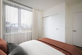 Happy Valley apartment for rent - A bedroom with a large bed and a view of the city through the window.