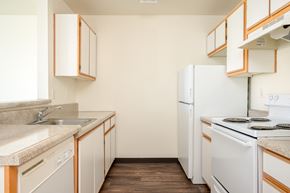 Hillsboro apartment for rent - A kitchen with white appliances and wooden cabinets.