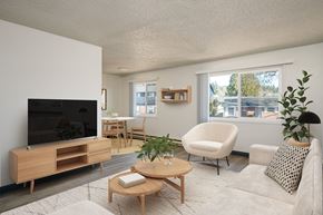 Milwaukie apartment for rent - A living room with a white couch, a wooden coffee table, and a flat-screen TV.
