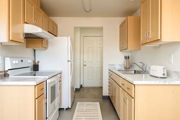 Milwaukie apartment for rent - A kitchen with wooden cabinets and a white refrigerator.