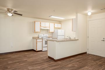 Tualatin apartment for rent - A kitchen with white cabinets and a wooden floor.