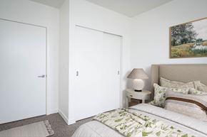 St Helens townhouse for rent - a bedroom with white walls and a bed with green and white bedding