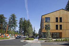 Portland apartment for rent - a city street with a yellow building on the left and trees on the right