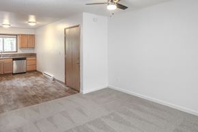 Portland apartment for rent - a living room with a ceiling fan and a kitchen in the background