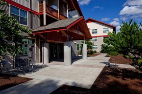 Beaverton apartment for rent - A building with a red roof and a covered walkway.