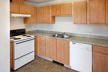 Beaverton apartment for rent - A kitchen with wooden cabinets and white appliances.